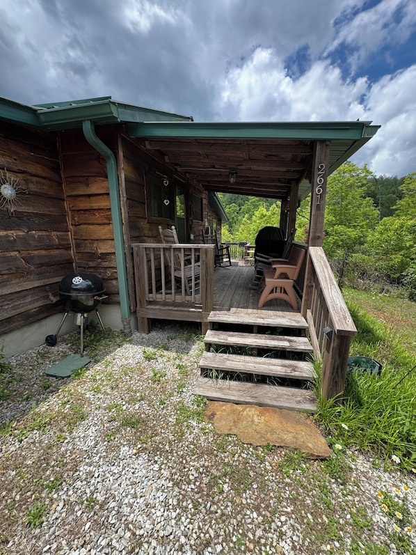 Un chalet rustique doté d’une véranda, d’un barbecue et d’une terrasse.