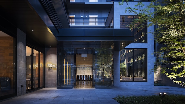 A modern building with a glass entrance, a visible sign reading "BSPK," and a well-lit interior. - Bespoke Hotel Shinsaibashi (Osaka)