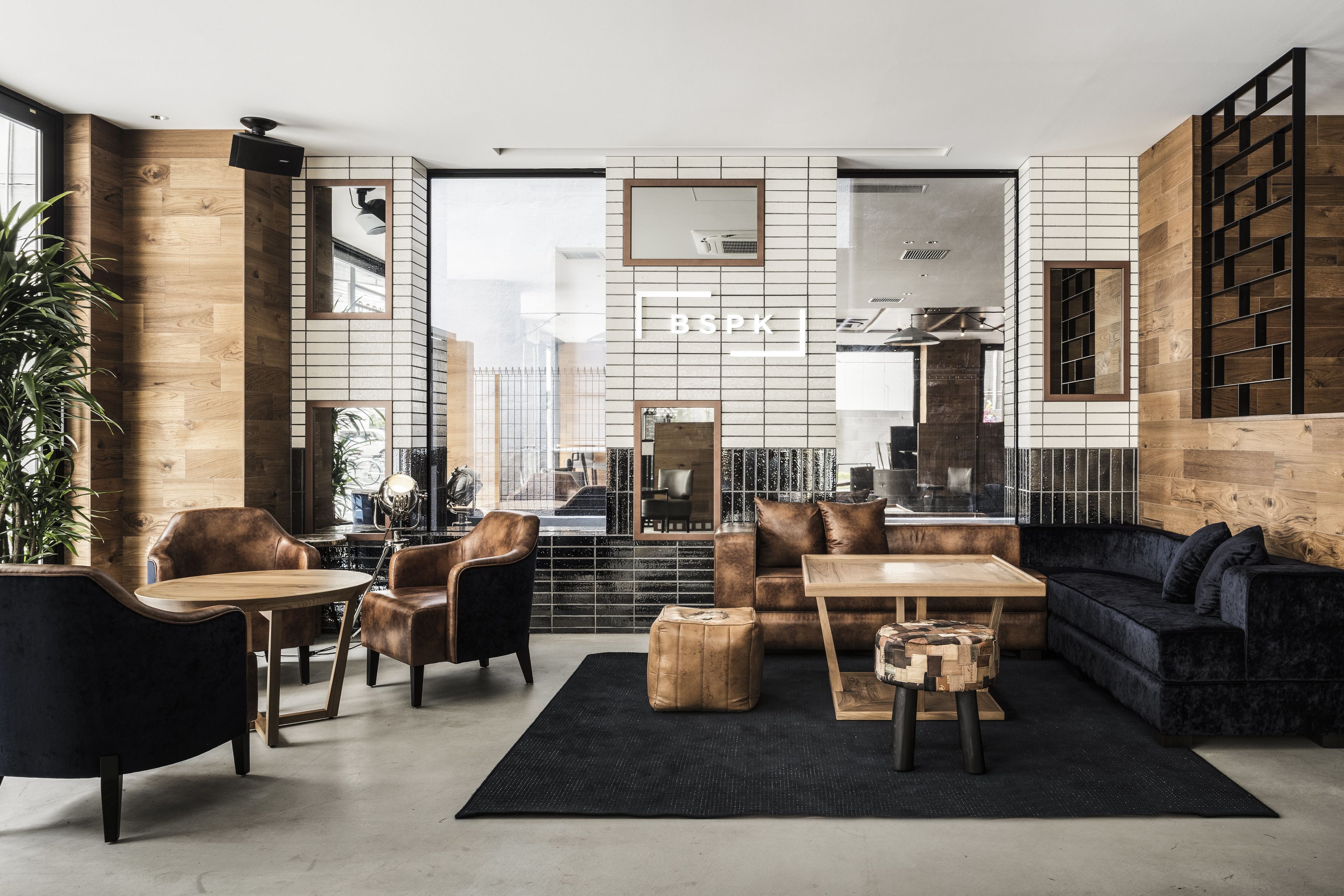Un salon moderne avec un canapé, des fauteuils, une table basse et un tapis.
