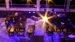An outdoor seating area with tables and chairs, under a covered structure with a starry light effect. - Hotel Ruby Arena (Thiruvananthapuram)