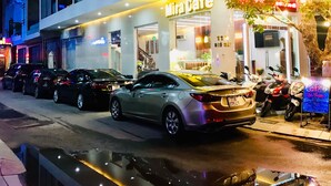 A hotel named 'Mirai Cafe' with a modern facade, parked cars, and a tree in front. - Mira Hotel (Quy Nhon Nam)