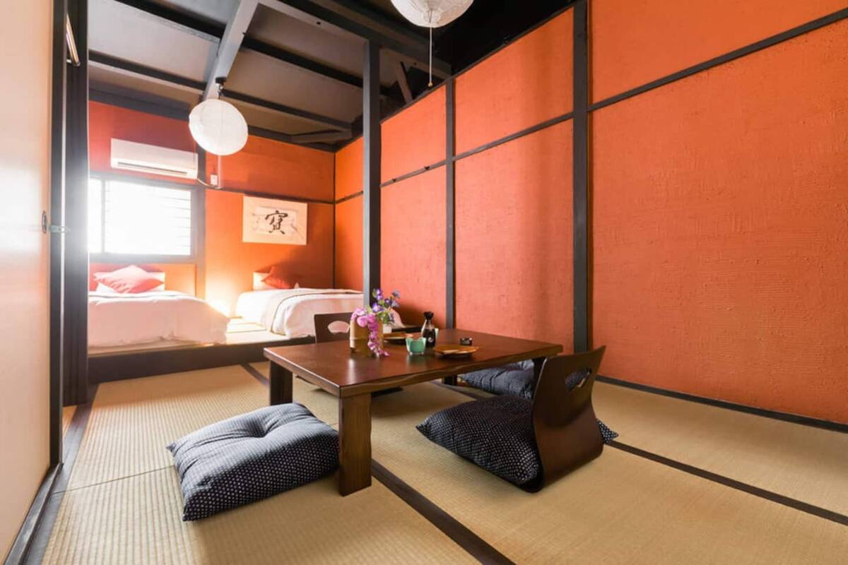 A traditional Japanese room with tatami flooring, a low wooden table, and cushions.
