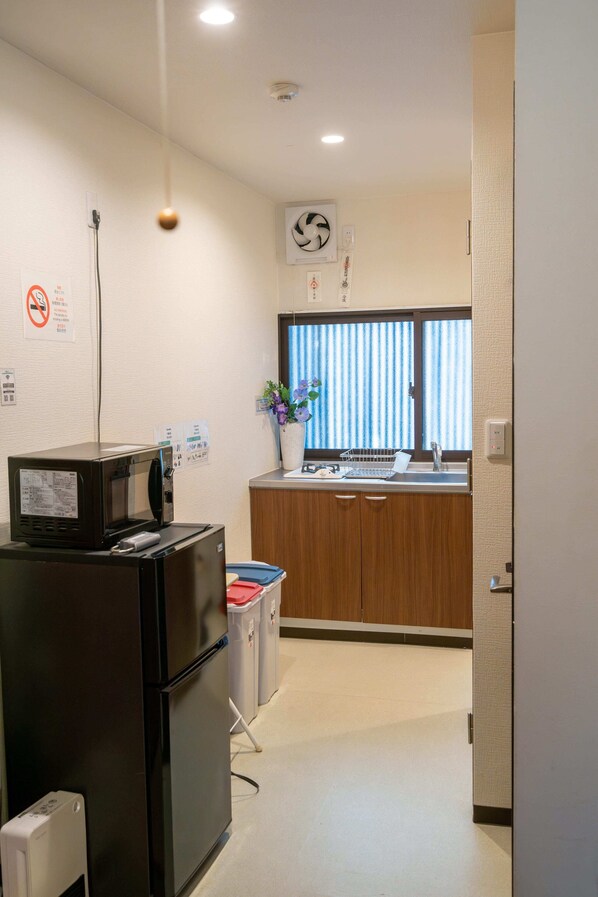 A compact kitchen with a refrigerator, microwave, and sink. - NAKAZ Machiya , Osaka Umeda (Osaka)