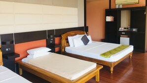 A hotel room with two single beds, a wooden headboard, a small desk with a chair, a wardrobe, and a mirror. - Parklane Bohol Resort and Spa (Anda)