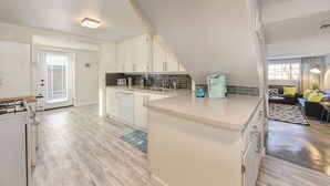Una cocina moderna con armarios blancos, horno integrado y una isla grande.