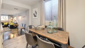 Un comedor con una mesa de madera, sillas y botellas decorativas.