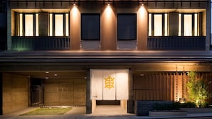 Un bâtiment moderne doté d’une grande entrée, de fenêtres illuminées et d’un logo bien visible sur la façade.