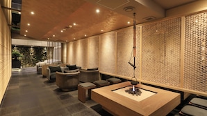 Un intérieur moderne avec un comptoir d’accueil en bois, un espace salon et des panneaux muraux décoratifs.