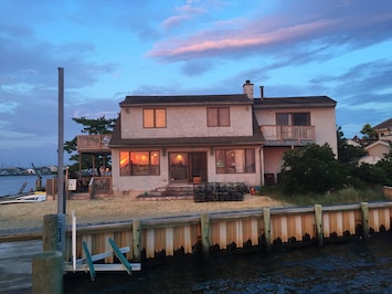 View from the end of our dock on the bay.  Sunset reflection in windows
