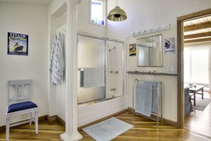 A bathroom with a shower, a chair, a towel rack, a mirror, and a poster on the wall. - Mermaid's House (Crew Quarters) - Tomales Bay Waterfront, Point Reyes, Marshall (Marshall)