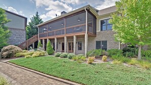 A two-story house with a balcony, stone exterior, and a well-maintained garden. -  Family  Friendly Retreat on Lake Burton- Sleeps 12 (Clarkesville)