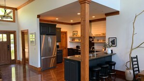A spacious kitchen with a central island, dark cabinetry, and a stainless steel refrigerator. -  Family  Friendly Retreat on Lake Burton- Sleeps 12 (Clarkesville)