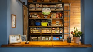 A wooden shelf with books, a map, and a sign for Bodegataler Basecamp Lodge. - Bodetaler Basecamp Lodge (Oberharz am Brocken)