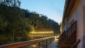 A wooden deck with a railing, a lantern, and a candle on a wooden stool. - Bodetaler Basecamp Lodge (Oberharz am Brocken)