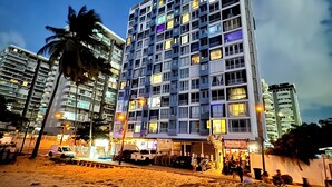 A high-rise hotel with multiple floors, balconies, and a beachside location. - DREAM ESCAPE - TWO BEDROOM OCEANFRONT 
SEAS THE DAY, THE OCEAN IS YOUR NEIGHBOR. (Isla Verde)