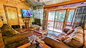 Een gezellig cabin interieur met een stenen openhaard, houten meubels en een televisietoestel.
