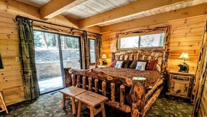 Een rustieke houten kamer met een bed, een bankje en een tafel.
