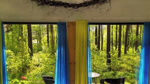 Une pièce avec de grandes fenêtres, une table et deux chaises.