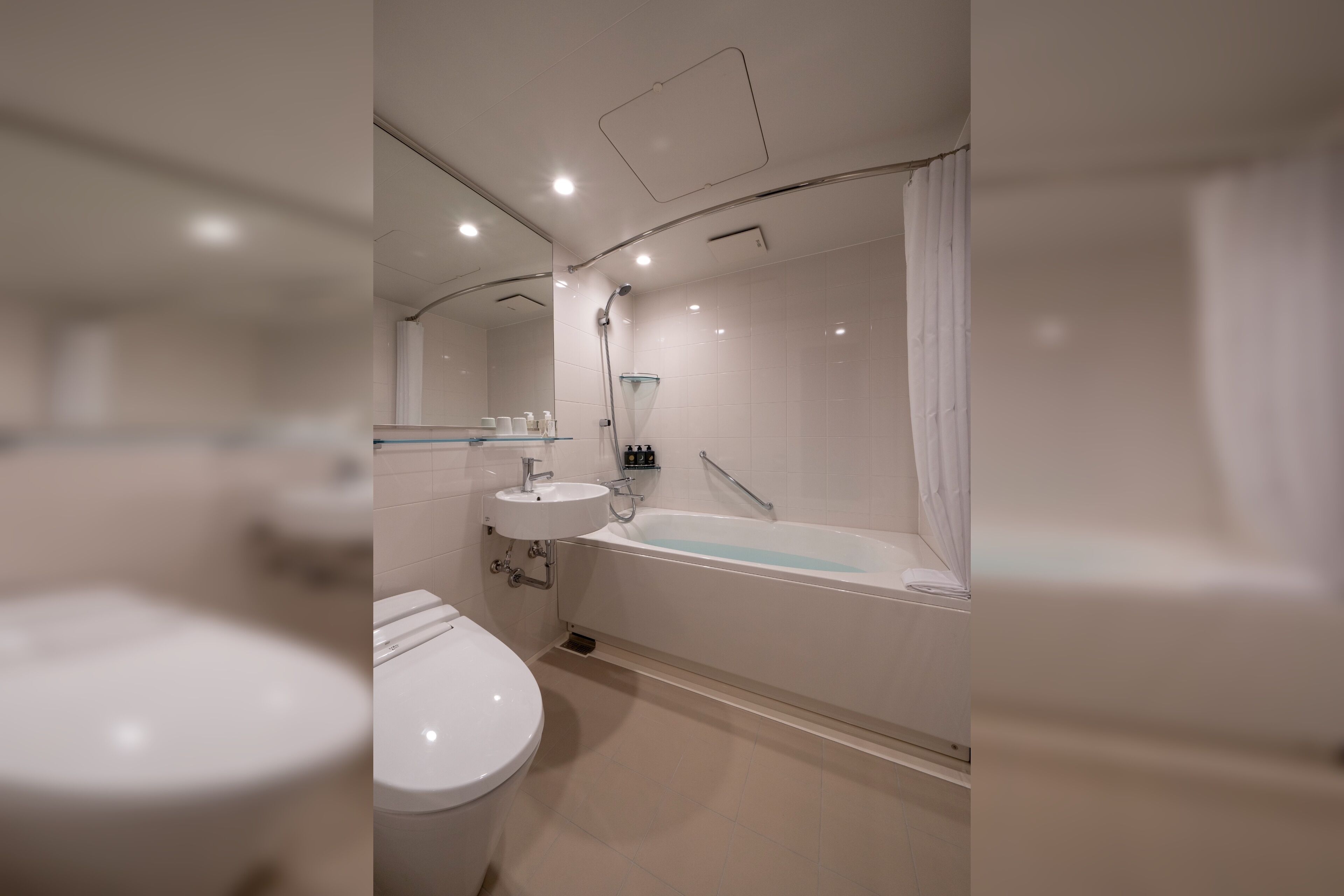 A modern bathroom with a toilet, sink, and bathtub.
