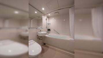 A modern bathroom with a toilet, sink, and bathtub.