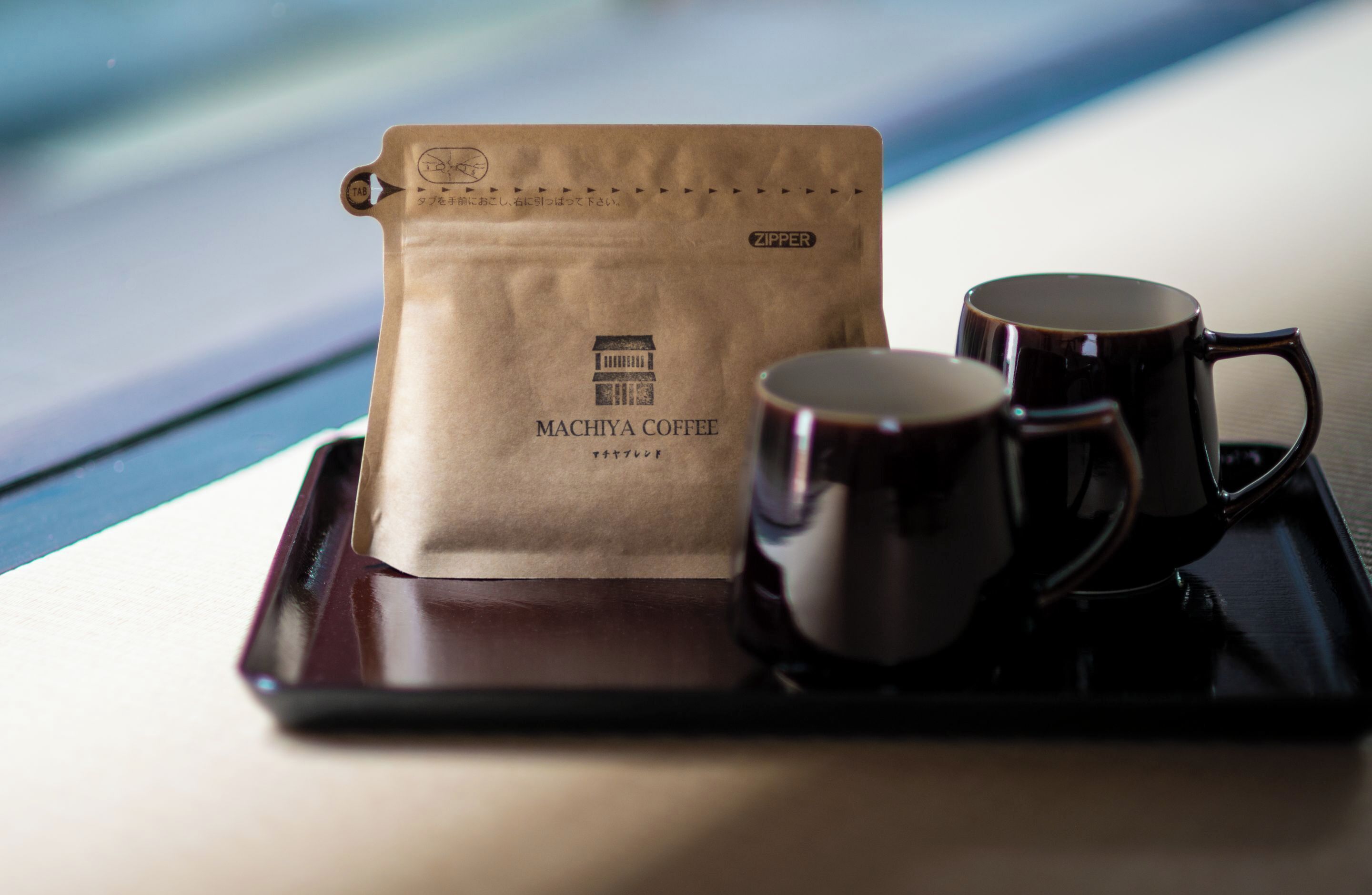 A tray with a coffee bag and two mugs.