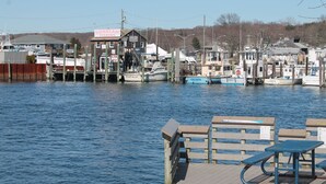 A marina with docked boats, a wooden pier with benches, and a building labeled 'Sunbeam Fishing'. - Walk to the  beach and Kayak at Black Point, Niantic, Ct. (Niantic)