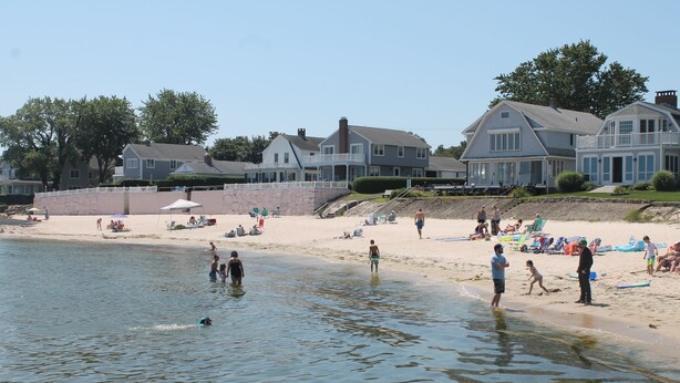 A beach with houses in the background and people enjoying the water. - Walk to the  beach and Kayak at Black Point, Niantic, Ct. (Niantic)