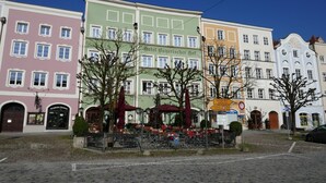 A row of colorful buildings with a cobblestone street in front. - Hotel Bayerischer Hof (Burghausen)