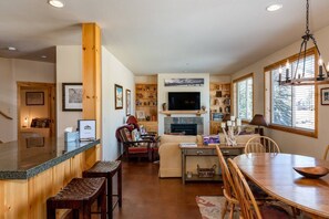Relax in this open-plan living space with a kitchen and dining area, featuring a TV and comfortable seating.