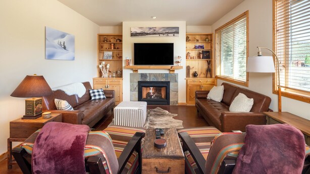A cozy living room with a fireplace, comfortable seating, and a television. - Luxurious, affordable condo one mile from downtown (Ketchum)