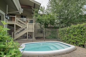 Enjoy a retreat with a balcony overlooking a serene garden and a small pool surrounded by lush greenery.