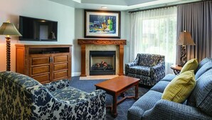 A living room with a fireplace, patterned furniture, a television, and a painting on the wall. -  NAPAS GEM!  1 BEDROOM (Napa)