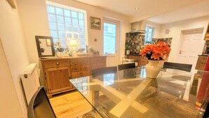 A modern kitchen with a large island, wooden cabinets, and a view of the backyard.