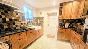 A kitchen with wooden cabinets, a black countertop, and a tiled backsplash.
