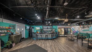 A bar area with a counter, chairs, and a seating area with tables and chairs.