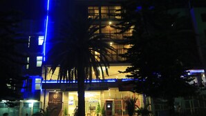 A multi-story hotel with a prominent blue neon sign at the top. - Wynn Hotel - Bahir Dar (Bahir Dar)