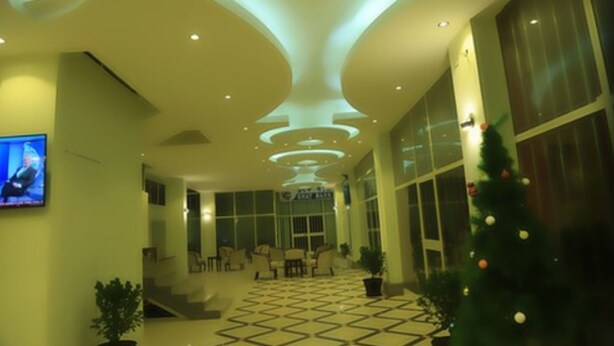 A lobby with a modern ceiling design, a Christmas tree, and a television screen. - Wynn Hotel - Bahir Dar (Bahir Dar)