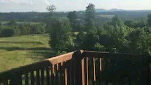 A balcony with a view of a green landscape and distant hills. - LOG HOME CANINE RETREAT (Pyatt)