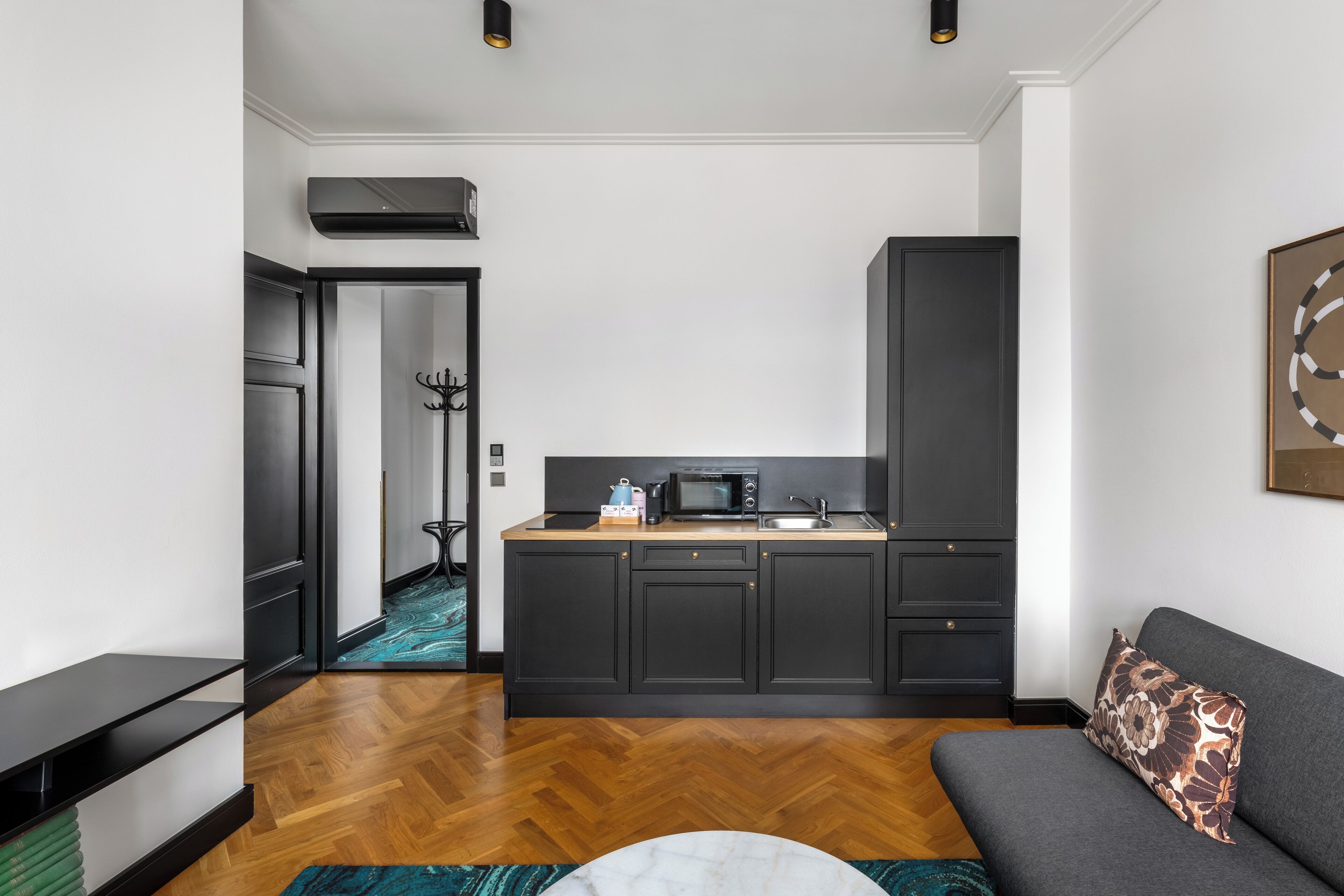 Une cuisine moderne avec des meubles de couleur sombre, un four à micro-ondes et un évier.