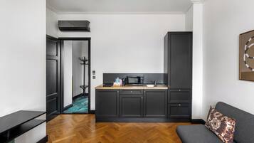 Une cuisine moderne avec des meubles de couleur sombre, un four à micro-ondes et un évier.