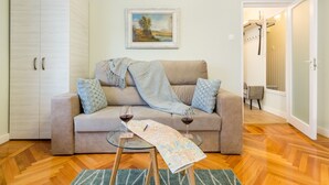 Ein gemütliches Wohnzimmer mit einer Couch, einem Glastisch mit einer Landkarte und einem Bild an der Wand.