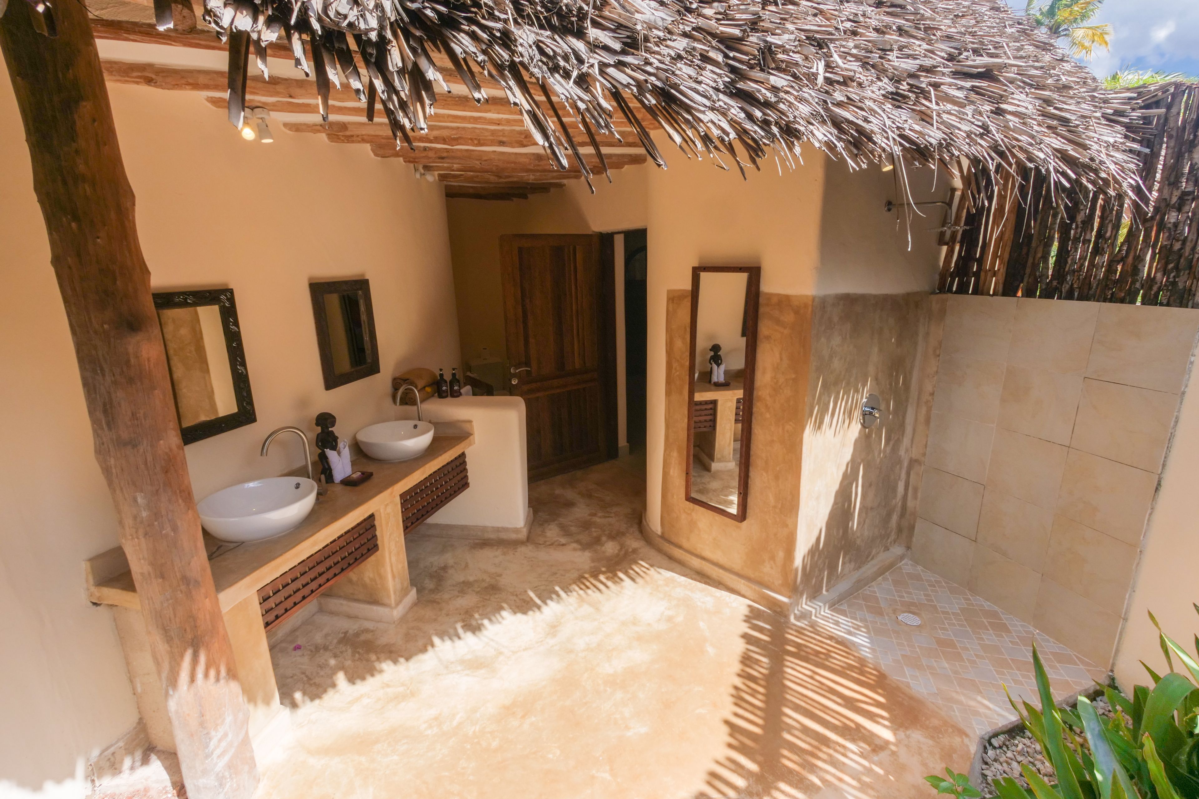 A bathroom with two sinks, a mirror, and a shower area.