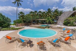 Una piscina al aire libre, sillones reclinables de piscina