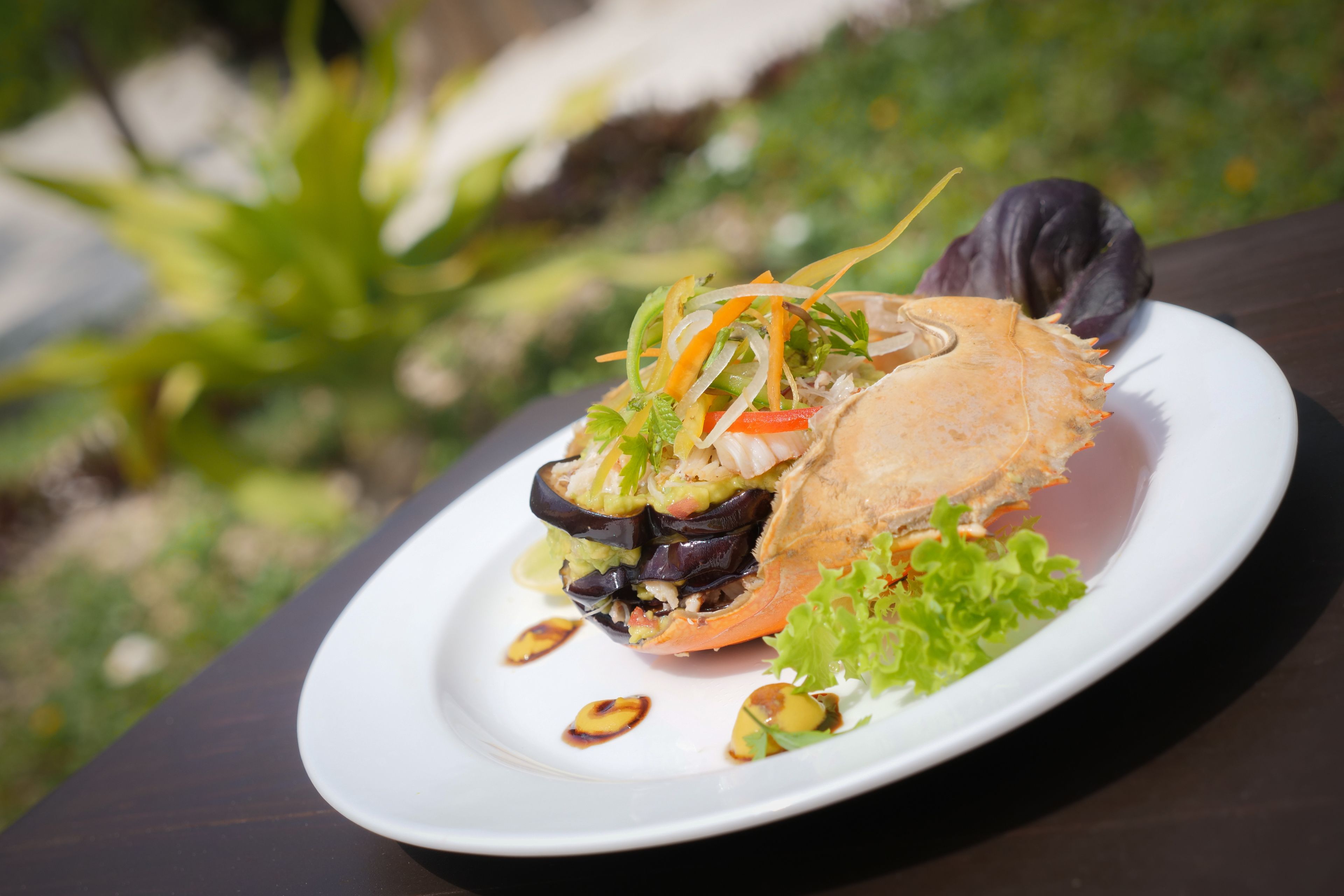 A seafood dish on a white plate with a dark background.