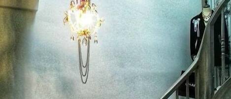 A staircase with a metal railing and a chandelier.