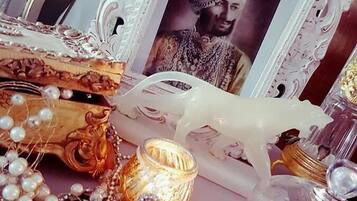 A decorative table with a framed photo, pearls, and a candle.