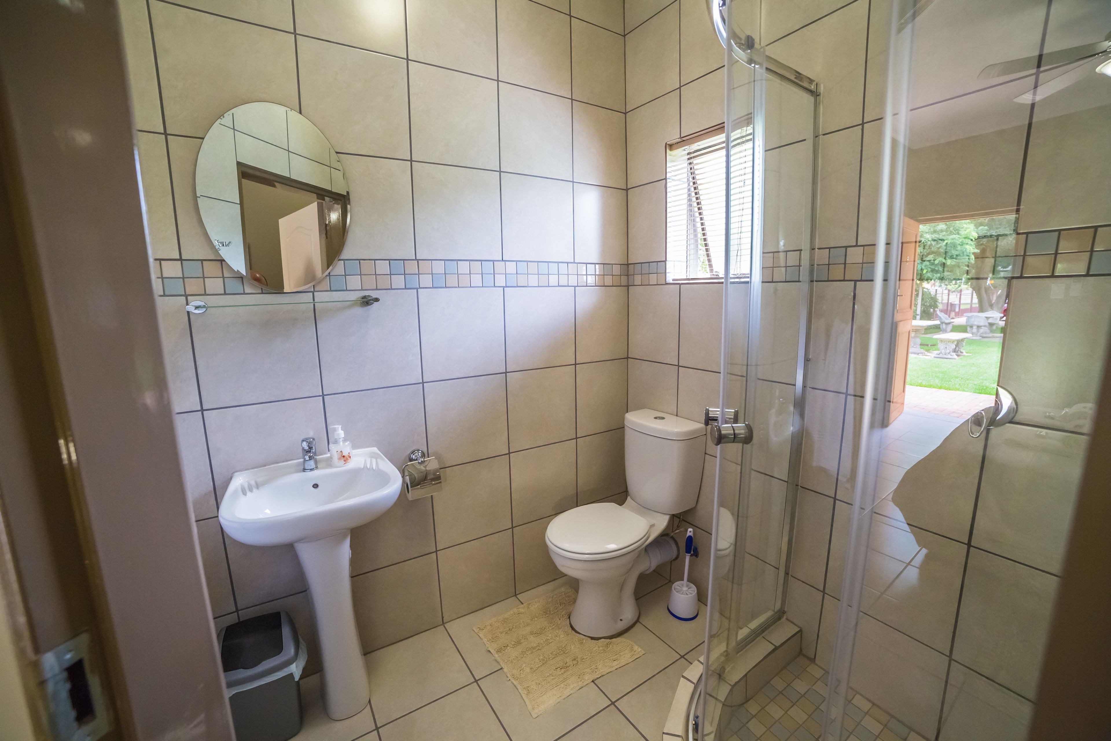 A bathroom with a toilet, sink, and shower.