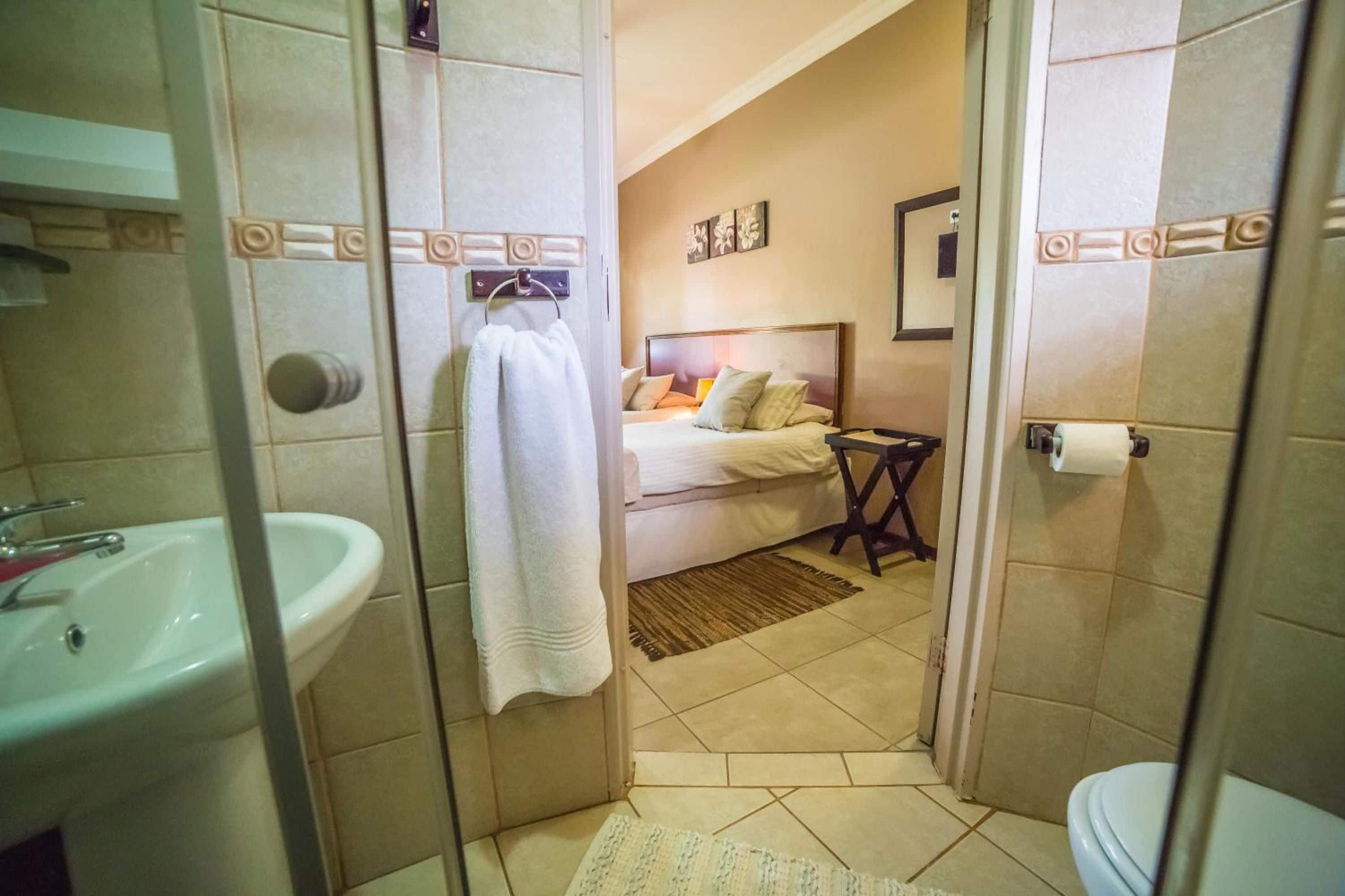 Un baño con lavamanos, inodoro y zona de ducha.