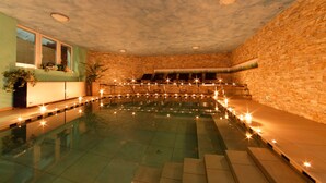 A swimming pool with a stone wall and a window on one side. - Hotel Leitner (Rio di Pusteria)