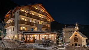 A multi-story hotel with balconies, a covered entrance, and a snow-covered ground. - Hotel Leitner (Rio di Pusteria)